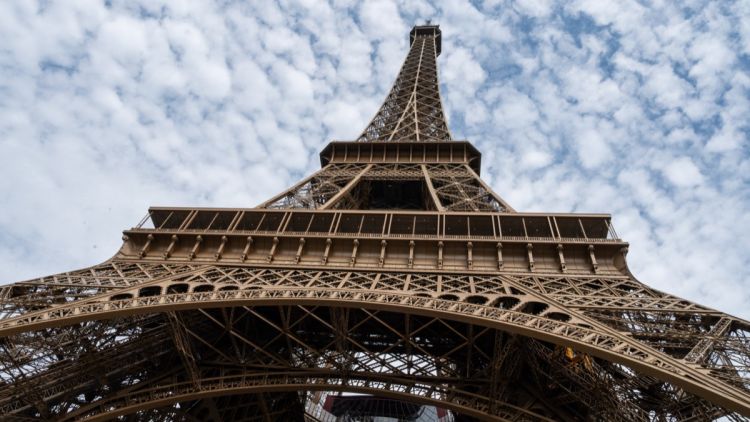 Un homme escalade la tour Eiffel et accroche un drapeau américain